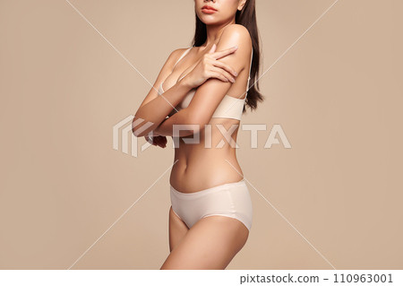 Confident beautiful young asian woman posing in white lingerie on beige background, Perfect body, 110963001