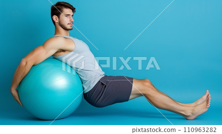 Athletic man performing stability ball roll out for controlled core exercise and strength training 110963282