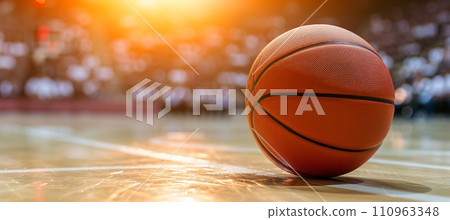 Basketball game in stadium with spotlight, court, and ball on floor, space for text placement 110963348