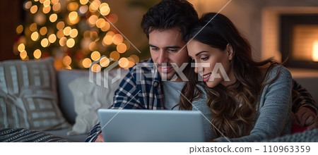 Multiracial young couple bonding and enjoying time together on sofa watching laptop at home Multiracial young couple bonding and enjoying time together on sofa watching laptop at home 110963359