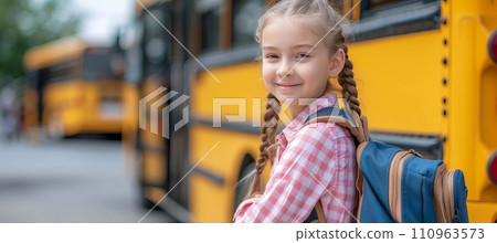 Cheerful elementary school girl ready to board school bus with copy space for text placement Cheerful elementary school girl ready to board school bus with copy space for text placement 110963573