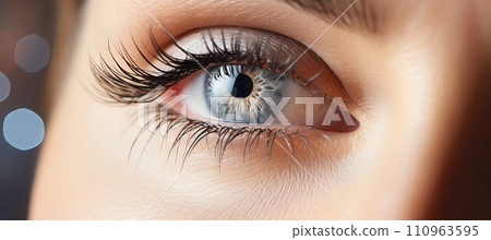 Intense gaze of female eye with long eyelashes on blurred background, perfect for text placement Intense gaze of female eye with long eyelashes on blurred background, perfect for text placement 110963595