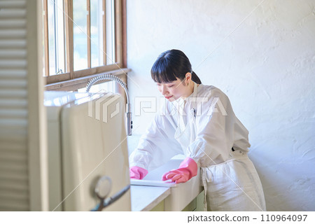 Young woman cleaning the kitchen sink 110964097