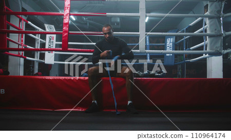 African American boxer sits and wraps his hands with bandage 110964174
