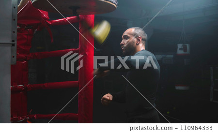 African American fighter hits punching bag during workout 110964333