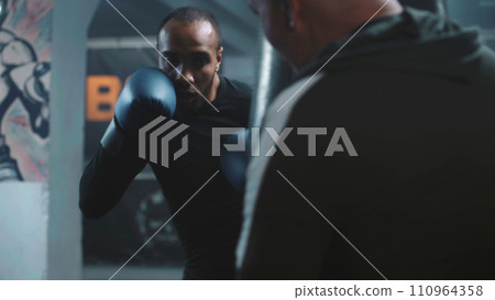 Athletic teenager in boxing gloves exercises before fighting Athletic teenager in boxing gloves exercises before fighting 110964358