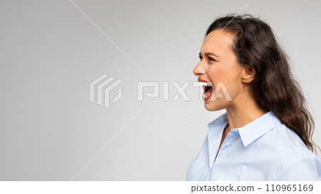 Angry despaired young caucasian lady in formal wear screams, freaking out 110965169