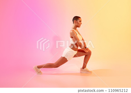 Focused active slim millennial latin woman athlete in sportswear doing lunges for legs 110965212