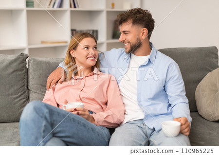 loving european young couple enjoying coffee together embracing at home loving european young couple enjoying coffee together embracing at home 110965225