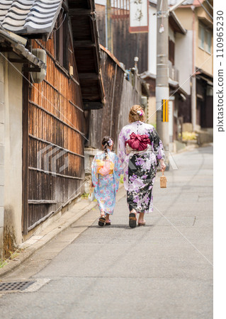 Rear view of a parent and child in yukata taking a walk 110965230