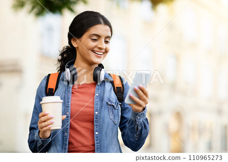 Student With Smartphone And Workbooks Standing Outdoors 110965273