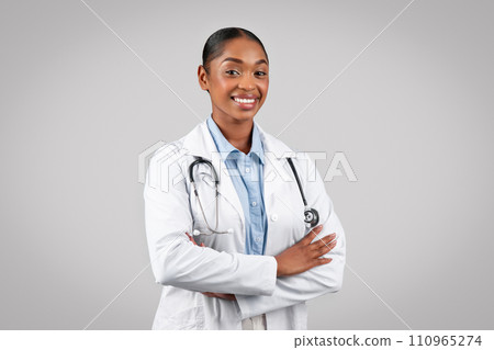 Professional cheerful black doctor smiling at camera, with arms crossed Professional cheerful black doctor smiling at camera, with arms crossed 110965274