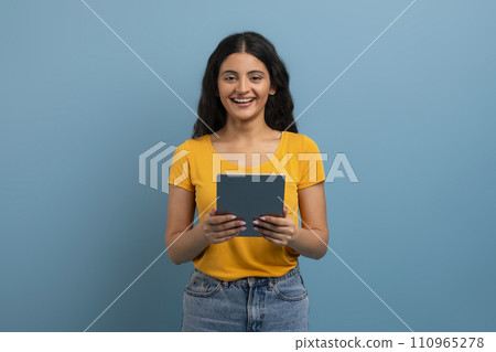 Cheerful Indian Lady Using Digital Tablet For Messaging With Friends Cheerful Indian Lady Using Digital Tablet For Messaging With Friends 110965278