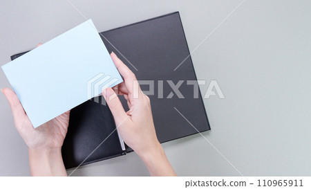 A square blue mockup card with empty space for text and design in hand of young woman on pink background. Color of year 2023 Viva Magenta. Board, blank, template, mockup, layout for a slogan. A square blue mockup card with empty space for text and design in hand of young woman on pink background. Color of year 2023 Viva Magenta. Board, blank, template, mockup, layout for a slogan. 110965911