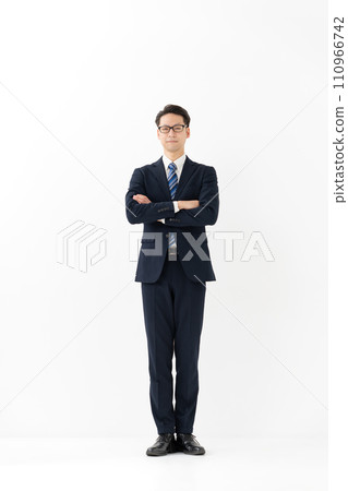 A businessman in a suit with his arms crossed 110966742