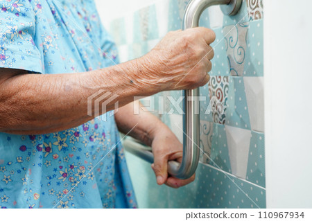 Asian elderly old woman patient use toilet support rail in bathroom, handrail safety grab bar, security in nursing hospital. Asian elderly old woman patient use toilet support rail in bathroom, handrail safety grab bar, security in nursing hospital. 110967934