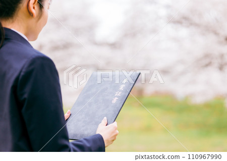 高中生和高中女生正在看畢業證書（畢業典禮、畢業生、畢業典禮、櫻花） 110967990