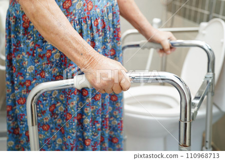Asian elderly old woman patient use toilet support rail in bathroom, handrail safety grab bar, security in nursing hospital. 110968713