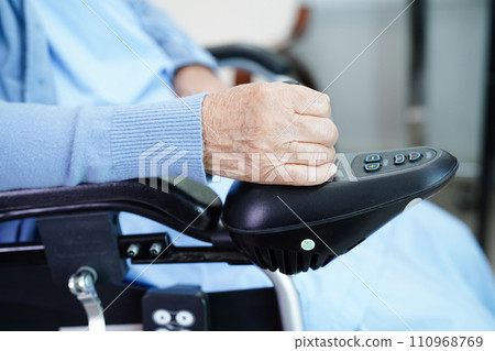 Asian elderly woman disability patient sitting on electric wheelchair in park, medical concept. 110968769