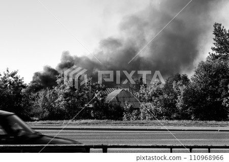 Fire in the city, from buildings and houses, black smoke. Black and white photo 110968966