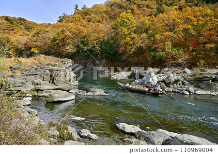 A pleasure boat sailing down the Nagatoro Line on the Arakawa River, which flows near the southern end of the rocky pavement of the Nagatoro Valley with its autumn leaves. A pleasure boat sailing down the Nagatoro Line on the Arakawa River, which flows near the southern end of the rocky pavement of the Nagatoro Valley with its autumn leaves. 110969004