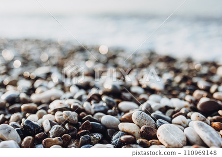 background of pebbles on the sea. Mediterranean coastal area. small sea stones. pebbles close up. photo of stones with bokeh effect background of pebbles on the sea. Mediterranean coastal area. small sea stones. pebbles close up. photo of stones with bokeh effect 110969148