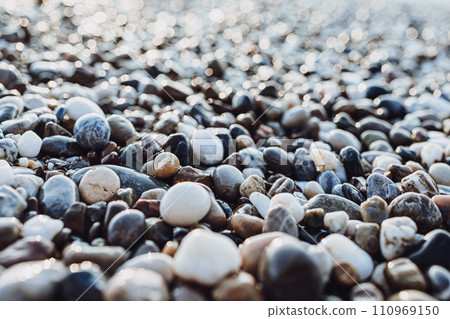 background of pebbles on the sea. Mediterranean coastal area. small sea stones. pebbles close up. photo of stones with bokeh effect background of pebbles on the sea. Mediterranean coastal area. small sea stones. pebbles close up. photo of stones with bokeh effect 110969150