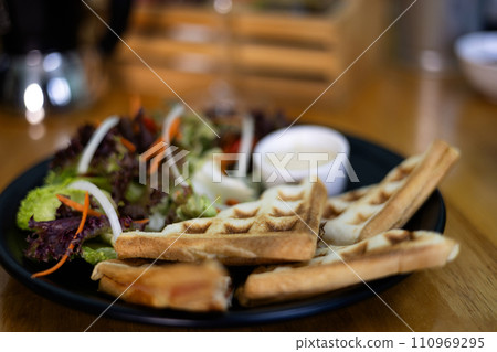 Served breakfast with waffles And Salad on light background. Delicious healthy food concept. 110969295