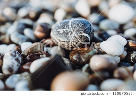 background of pebbles on the sea. Mediterranean coastal area. small sea stones. pebbles close up. photo of stones with bokeh effect. macro photography of stones background of pebbles on the sea. Mediterranean coastal area. small sea stones. pebbles close up. photo of stones with bokeh effect. macro photography of stones 110970555