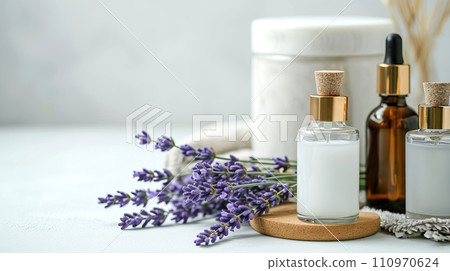 Beauty product display, slender flacons and oils, arranged with fresh lavender, on a monochrome ivory surface Beauty product display, slender flacons and oils, arranged with fresh lavender, on a monochrome ivory surface 110970624