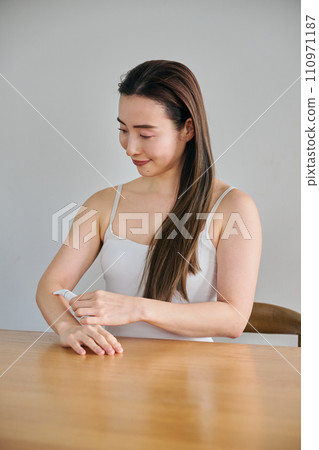 一名30多歲的女士用電動刮鬍刀剃手臂毛 一名30多歲的女士用電動刮鬍刀剃手臂毛 110971187