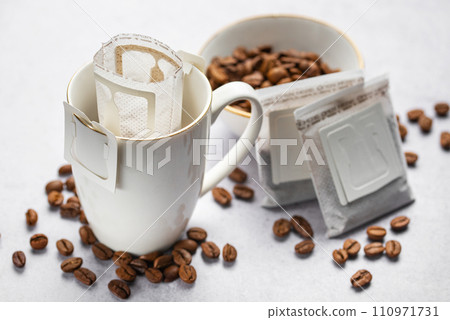 Drip coffee bag with ground coffee in cup Drip coffee bag with ground coffee in cup 110971731