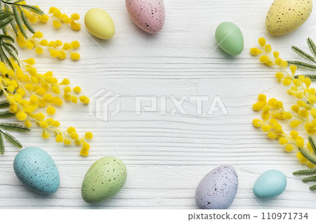 Colorful easter eggs  and mimosa flowers on wooden table. 110971734