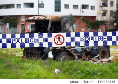 Australian police tape barricading a burnt truck 110972316