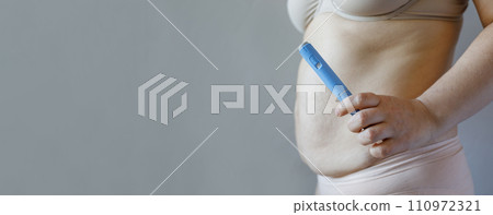 Female hand holding semaglutide injection pen or insulin cartridge pen for diabetics 110972321