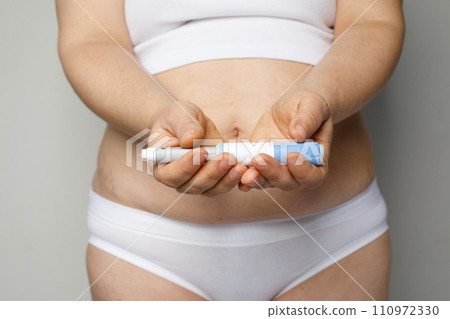 Curves woman body closeup with Semaglutide Injection pen or insulin cartridge pen. Curves woman body closeup with Semaglutide Injection pen or insulin cartridge pen. 110972330