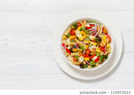 fusilli salad with mozzarella, veggies in a bowl 110972622