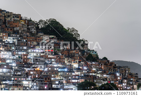 Illuminated Hillside Favela at Night in Urban Brazil 110973161