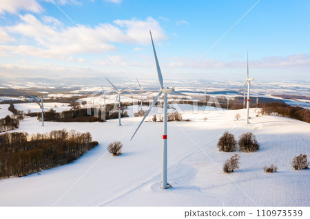 Aerial view of a wind turbine park in the winter field as a hub of renewable energy production 110973539