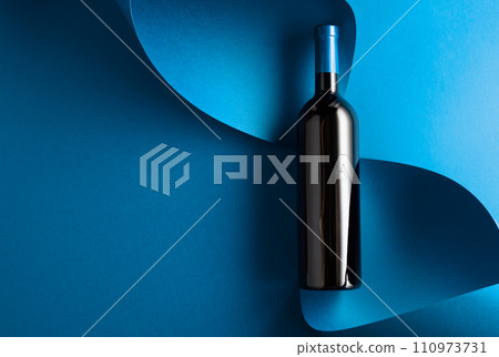 Bottle of red wine on a blue background. Bottle of red wine on a blue background. 110973731