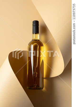 Bottle of white wine on a beige background. 110973735