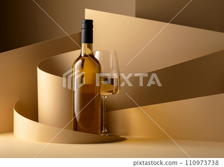 Bottle and glass of white wine on a beige background. 110973738