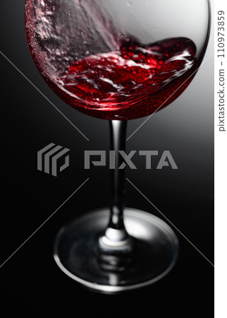 Closeup of red wine pouring. 110973859