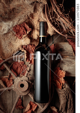 Bottle of red wine on a vintage rustic background. 110973863