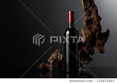 Red wine and old snag on a black background. Red wine and old snag on a black background. 110973883