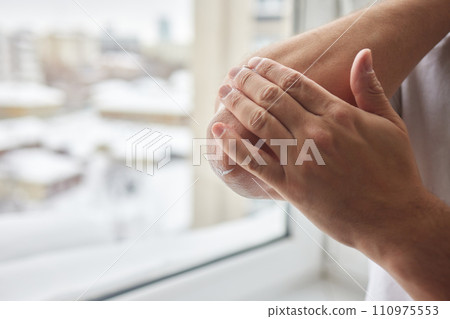 Senior man lubricating with analgetic cream his elbow. Senior man lubricating with analgetic cream his elbow. 110975553