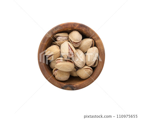 Top view of salted pistachios in wood bowl isolated on white background Top view of salted pistachios in wood bowl isolated on white background 110975655