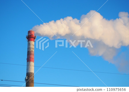 Smoke from a factory chimney. Ecological pollution. Air emissions polluting forest. Industrial waste. Industry metallurgical plant emissions. Smog and bad ecology. Central heating of CHP in winter 110975656