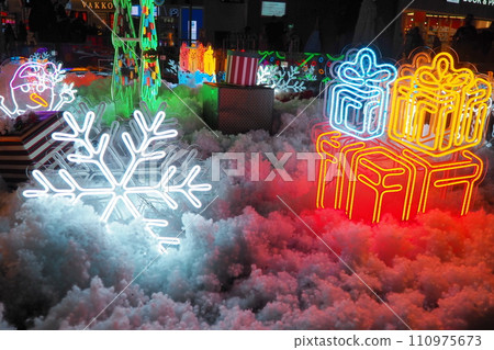 New Year and Christmas decorations, garlands, small architectural forms. Multi-colored light bulbs create festive atmosphere. A snowflake New Year and Christmas decorations, garlands, small architectural forms. Multi-colored light bulbs create festive atmosphere. A snowflake 110975673