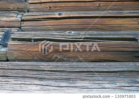 Background horizontal logs. Wooden background from shabby boards and logs. Round lumber assortment. General purpose lumber. Special type of forest products. Knots and branches. Background horizontal logs. Wooden background from shabby boards and logs. Round lumber assortment. General purpose lumber. Special type of forest products. Knots and branches. 110975803